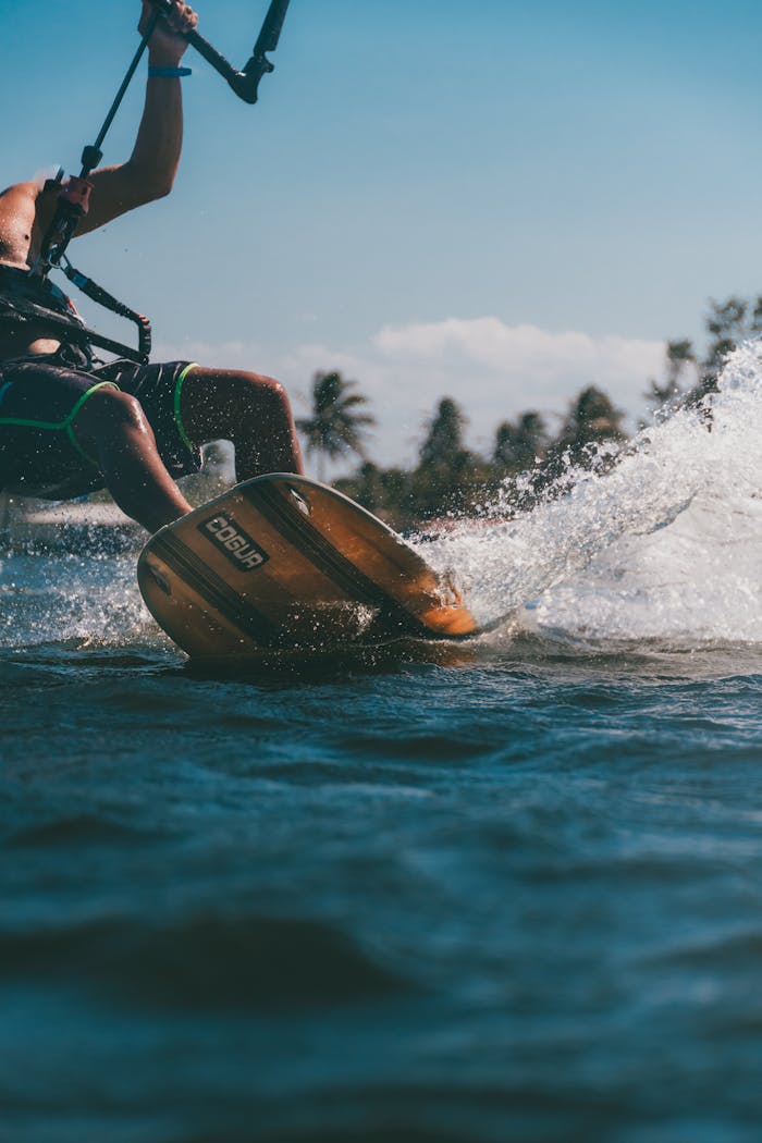 creative-03 Dynamic kitesurfing action with splashing waves and scenic background, showcasing water sports excitement.
