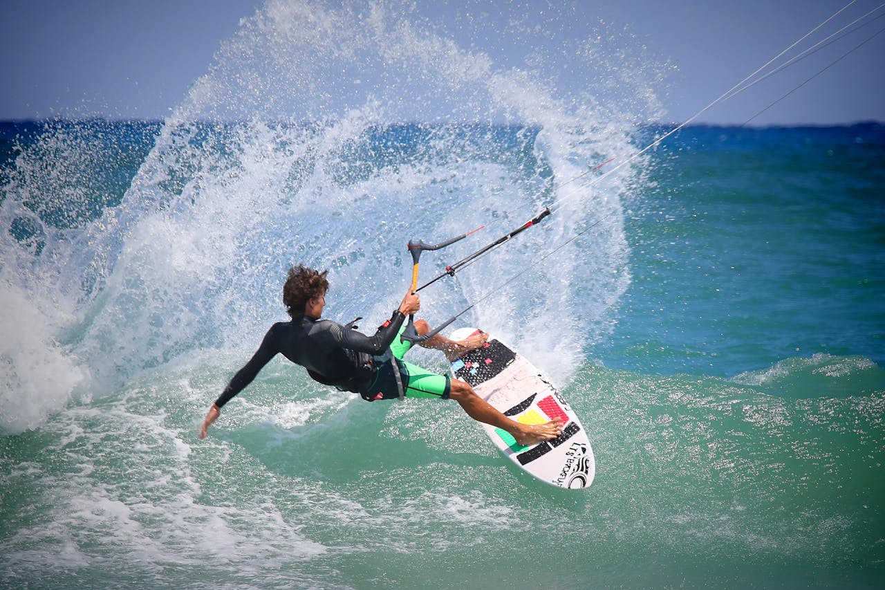 brand-01 A kiteboarder performing thrilling maneuvers on ocean waves on a sunny day.