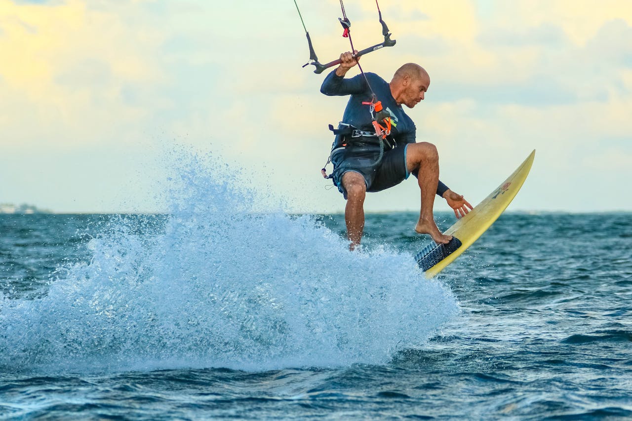 brand-02 Man kiteboarding on the ocean with waves and splashes, capturing action and excitement.